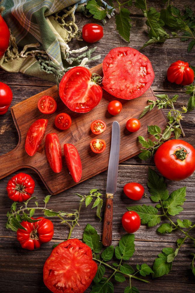 Flat lay of fresh ripe tomatoes on bread board