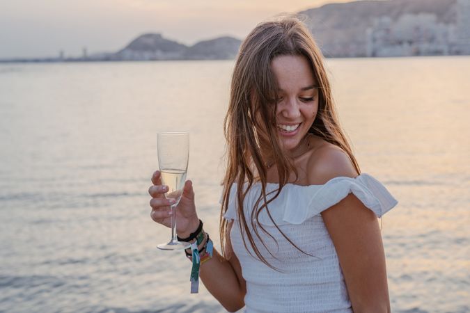 Young woman enjoying wine near sea