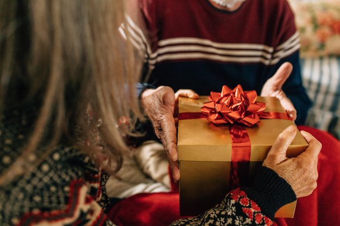 Close up of an older couple holding a gift box