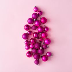 Arrangement of pink festive baubles on pink background