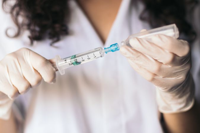 Nurse with syringe and serum.