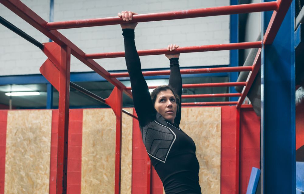 Sportswoman exercising on monkey bars