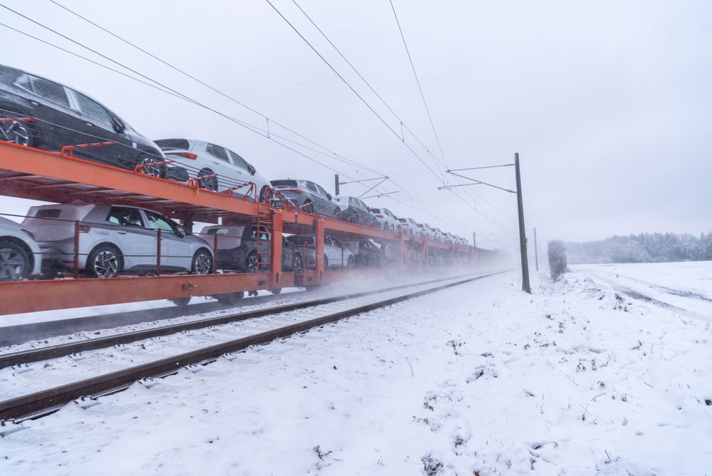 Freight train transporting cars through snow in Germany