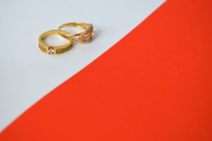 Two diamond gold wedding rings on duotone background