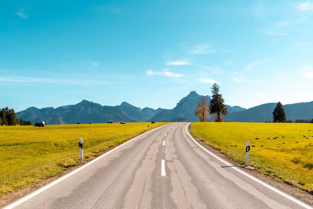 Landscape with an empty road in the Bavarian alps on a sunny day