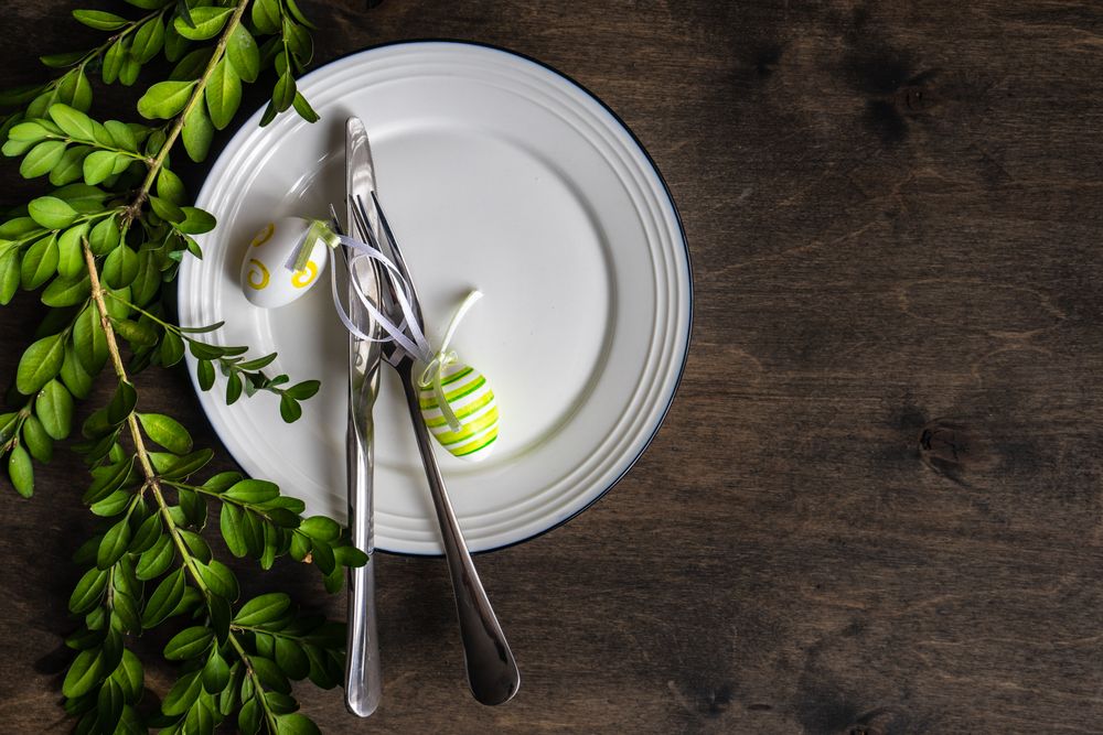Easter table setting with small green pastel egg decor and branch