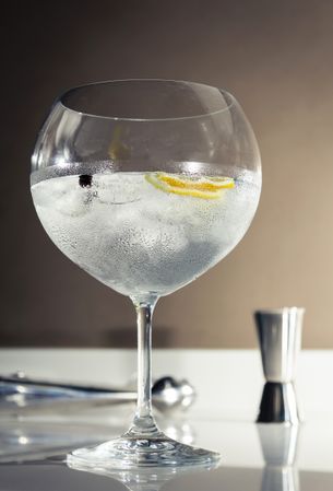 Gin tonic cocktail over a club bar background