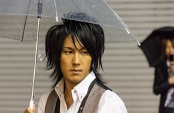 Japan - May, 10 2013: Asian man with umbrella looking away