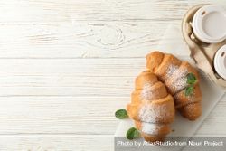 Croissant on wooden table with to go coffee, with space for text bGVLe4