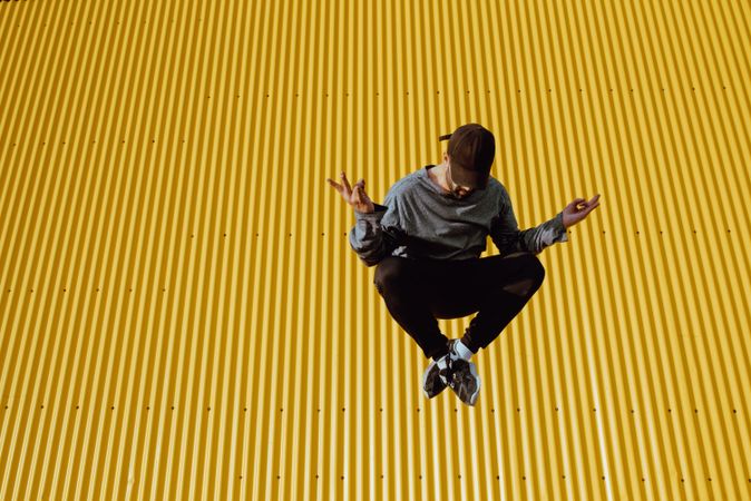 Man jumping near yellow wall