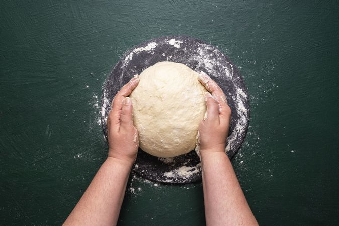 Woman hands holding kneaded dough