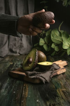 Person hands holding avocados