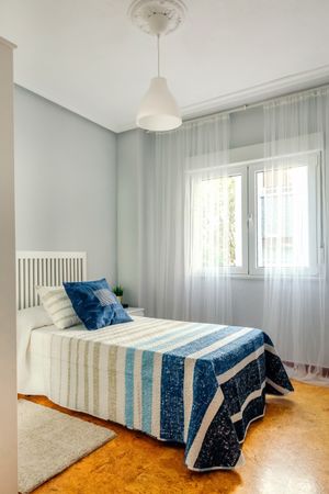Bedroom decorated with quilt and curtains
