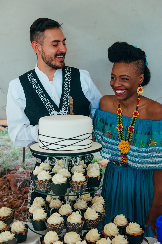 Bride and groom laughing before cutting the wedding cake