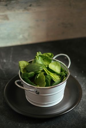 Fresh spinach on a rustic metal crockery bowl