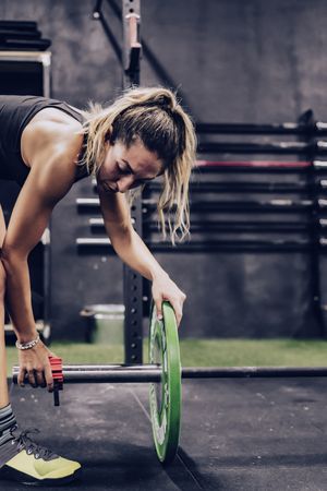 Concentrated female fixing barbell before workout