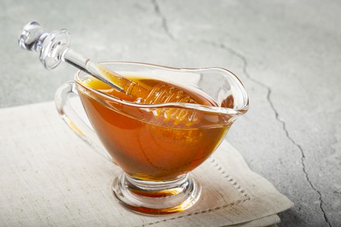 Honey in glass bowl on the table.