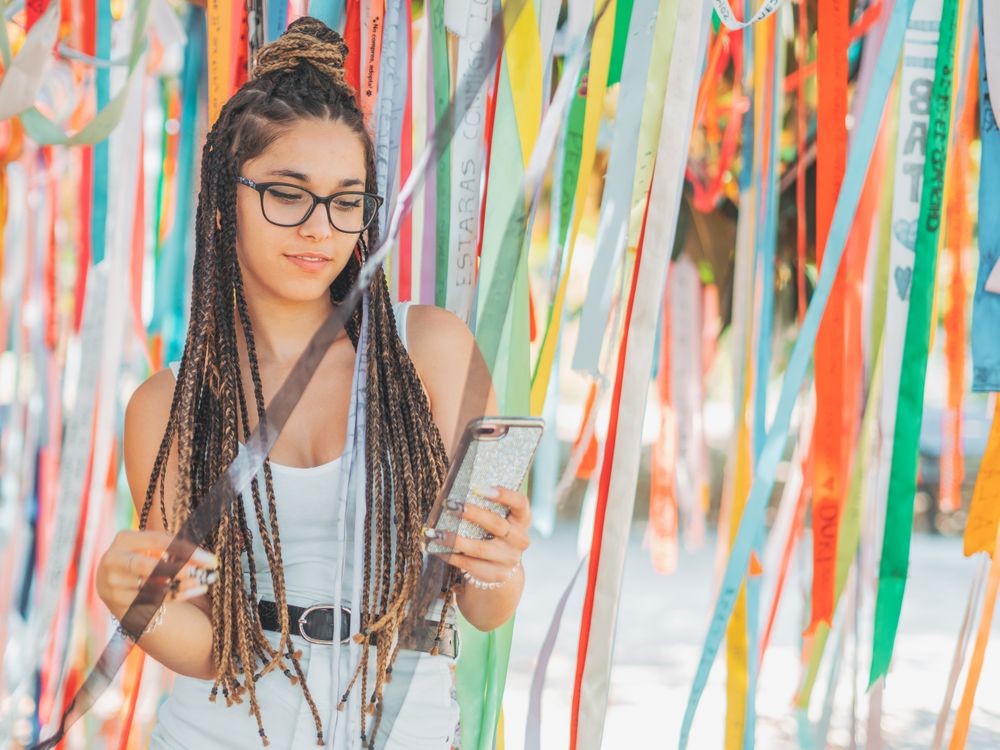 young woman using smartphone outside during festival