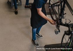 Person working on a bicycle in a repair shop 5roL24