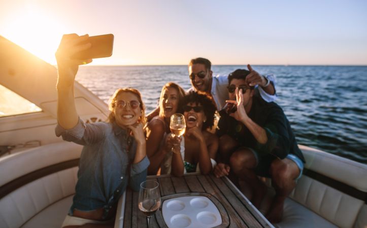 Group of friends posing with drinks in hand for selfie