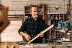 Bearded carpenter measuring wood in his studio 0VDPk4