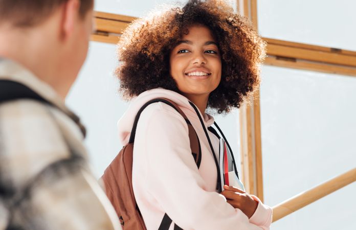 Female student smiling back at her male high school friend