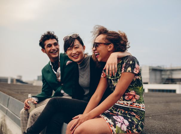 Shot of happy young friends relaxing together on rooftop