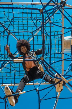 Woman with afro hair climbing by children's attractions.