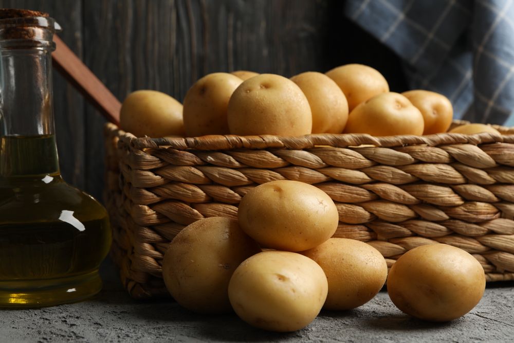 Wicker box of potatoes in dark room
