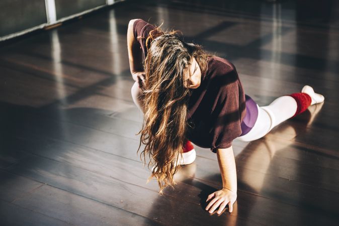 Confident ballet dancer warming up in sunny studio looking away with confidence.
