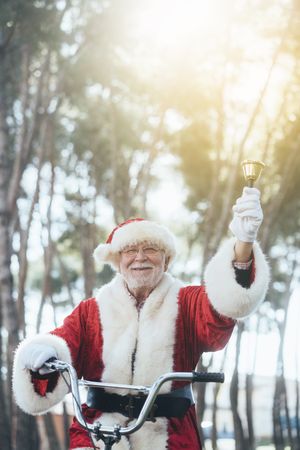 Happy Santa Claus riding bicycle by van