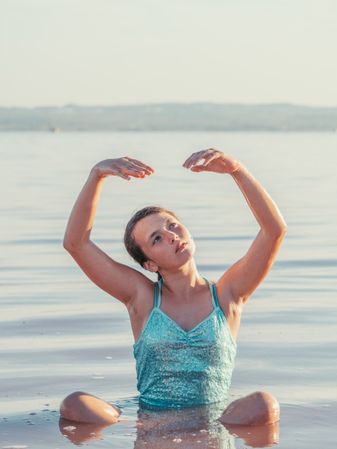 Teenage girl sitting in fresh water in sunny day