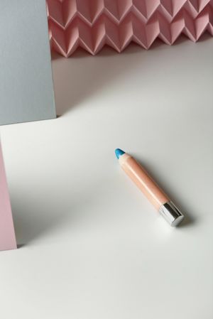 Cosmetic pencils:, make up blue eyeliner pencil, modern background with pink chevron reliefs. make up concept
