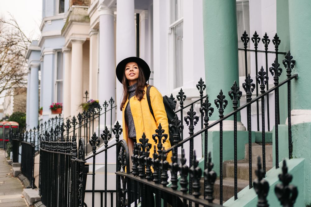 Cheerful woman standing in stairs in typical london buildings