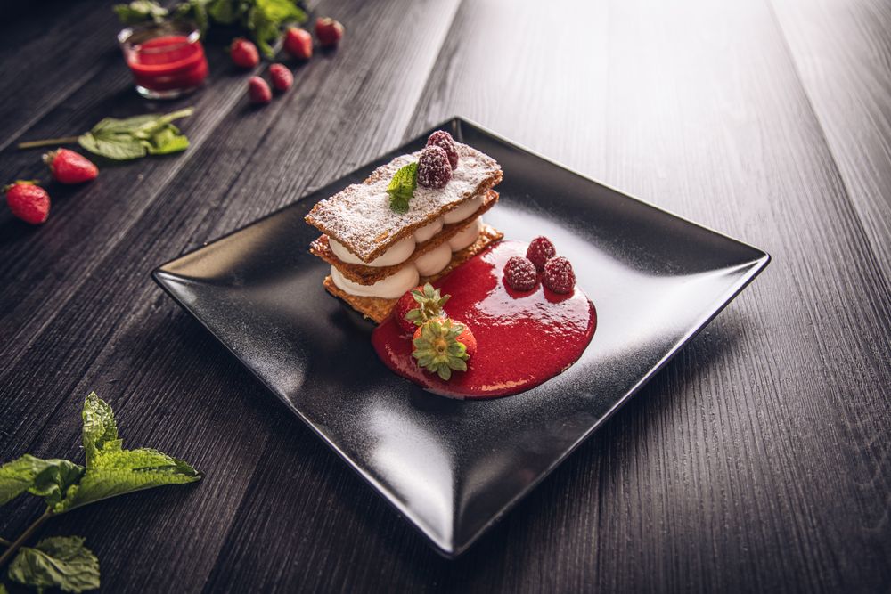 Diphlomate cream and red fruit strudel in elegant black plate