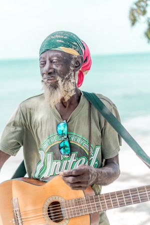 Jamaican man playing guitar