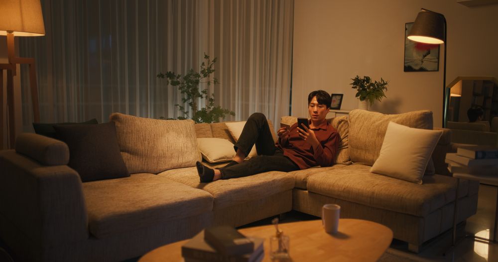 Young South Korean Man Using Online Shopping App in a Cozy Apartment
