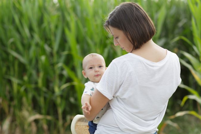 Adorable mother and child on hand enjoying and laughing in field