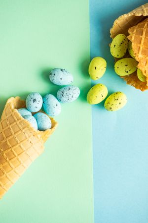 Waffle cone with speckled eggs on duo tone blue green pastel background