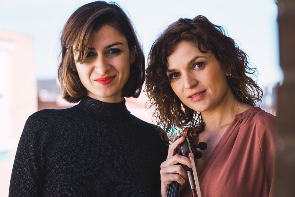 Young smiling women with violin on balcony