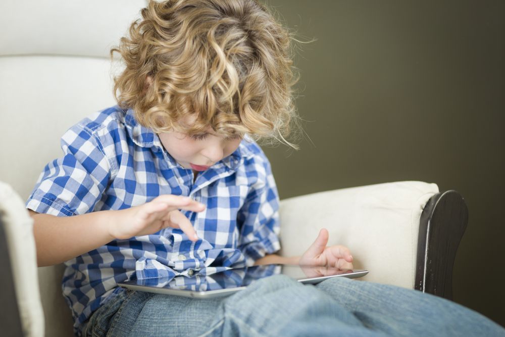 Young Blond Boy Using His Computer Tablet