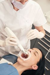 Dentist scanning oral cavity of patient in clinic