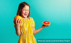 Girl with grapefruit on a blue background 0JKoN5
