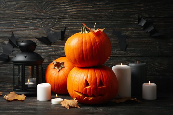 Pumpkins and halloween accessories on wooden background