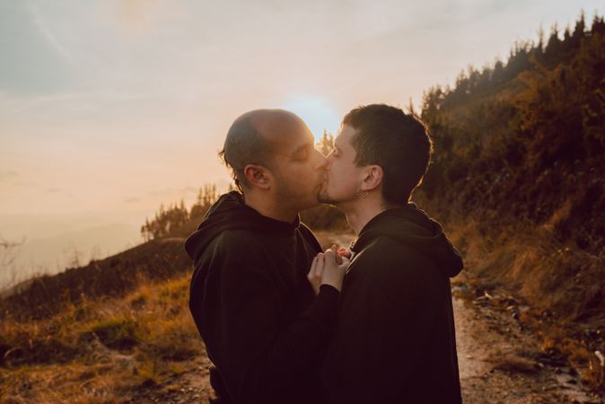 Men hugging and kissing in forest