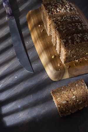 Sliced wholegrain bread on wooden cutting board