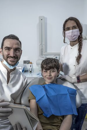 Portrait of dentist and patient ready for exam while looking camera