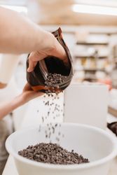 Crop confectioner spilling chocolate into bowl