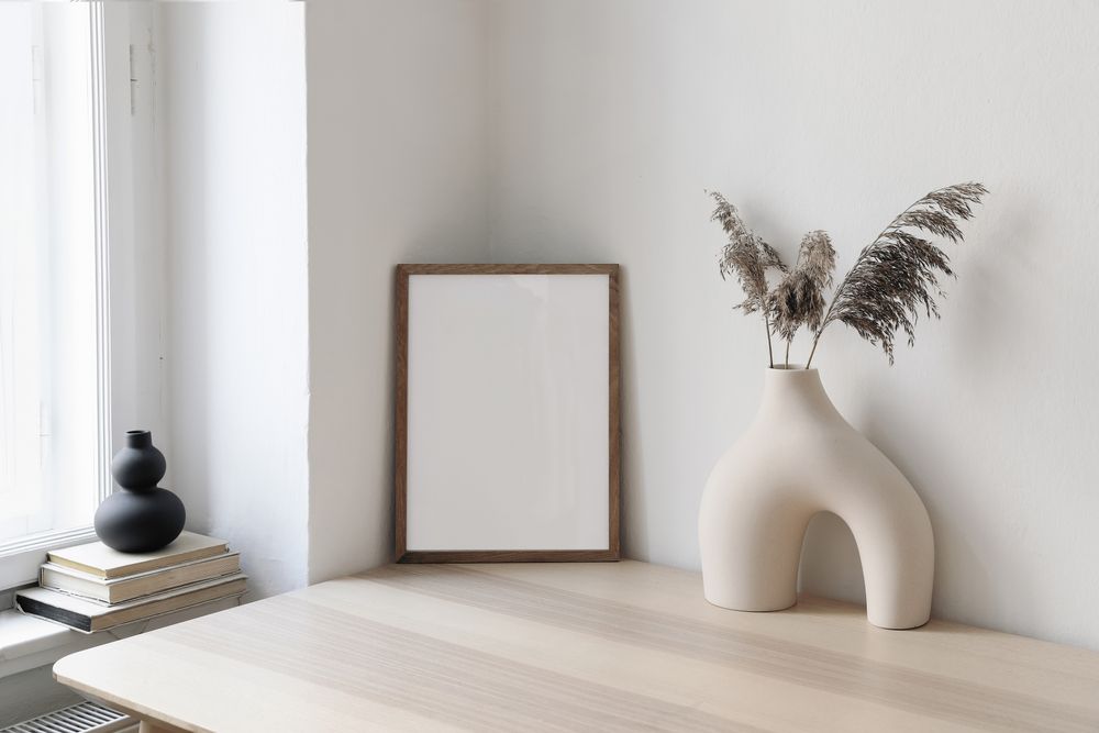 Table with modernist vase and decorative reeds and mock up frame