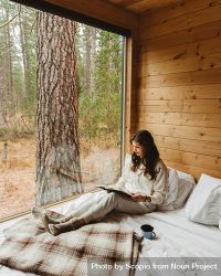 Woman in light comfy outfit lying on bed and reading 43BqO5